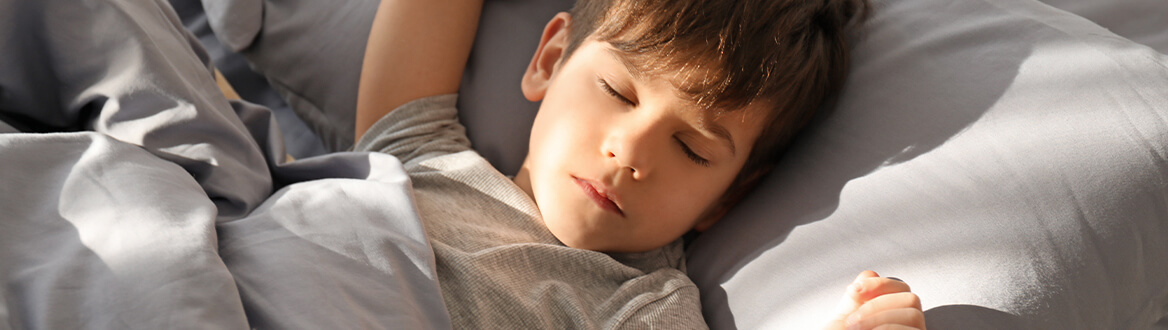 young boy sleeping in bed