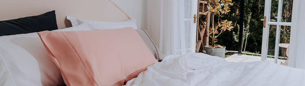 pink pillow on white bed